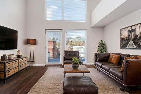 A living room with a brown leather couch and a wooden coffee table.