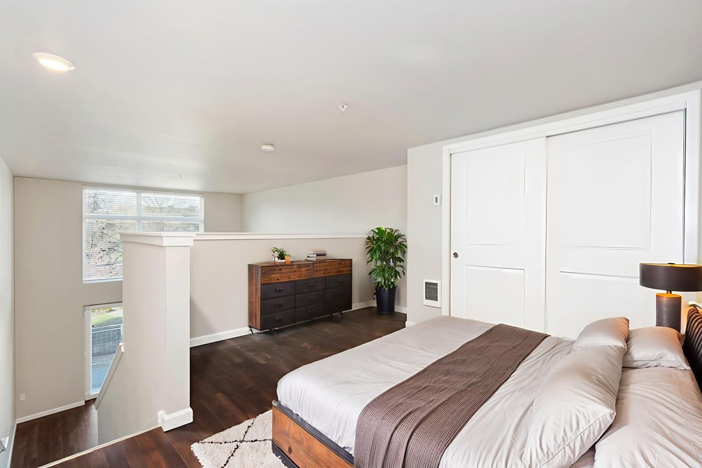 A bedroom with a large bed and a wooden dresser.