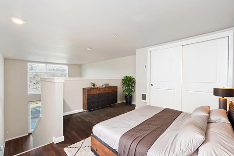 A bedroom with a large bed and a wooden dresser.