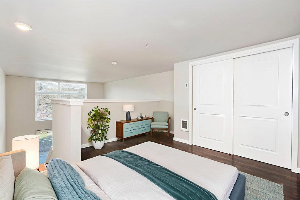 A bedroom with a large bed and a window.