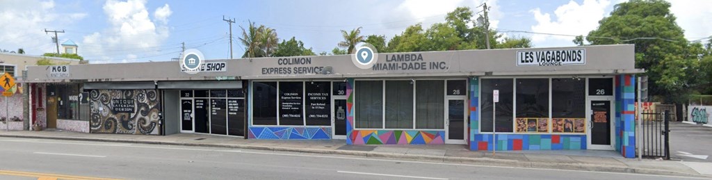 A row of stores including Colinon Express Service, Lambda Miami-Dade Inc., and Les Vagabonds.