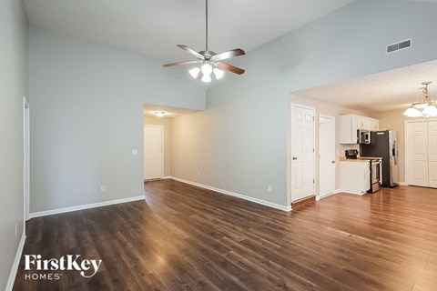A spacious room with a ceiling fan and wooden flooring.
