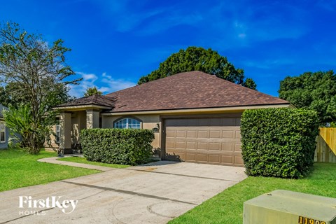 A house with a brown roof and a garage door is for sale.