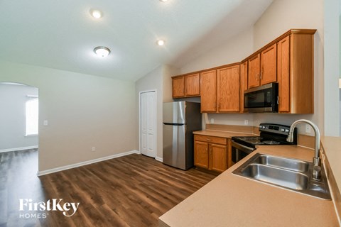 A kitchen with wooden cabinets and a stainless steel refrigerator.