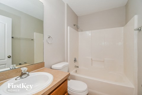 A white bathroom with a sink, toilet and bathtub.