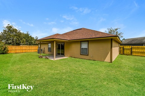 A house with a brown roof and a yellow fence is for sale.