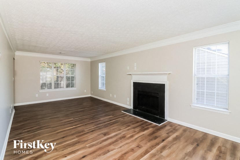 a living room with a fireplace and wooden floors