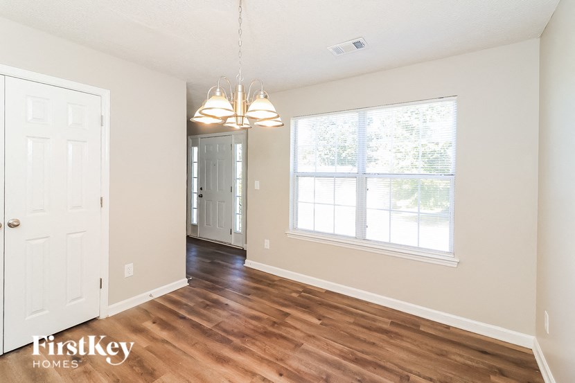 a living room and dining room with wood flooring and a large window