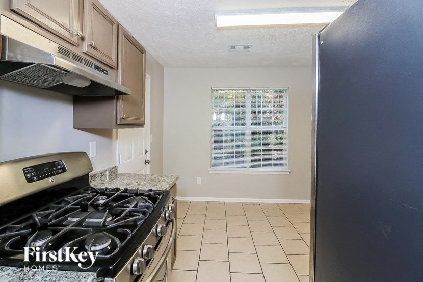 a kitchen with a stove and a refrigerator and a window