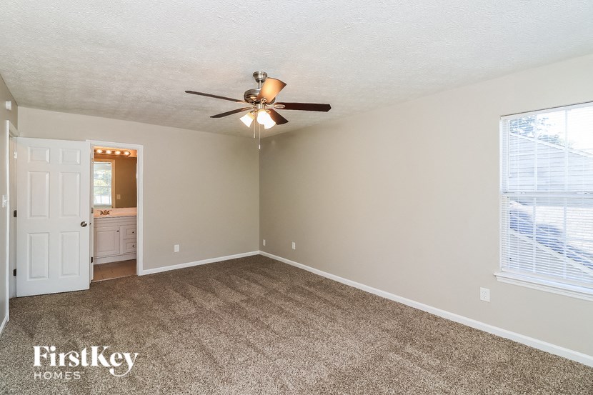 a living room with carpet and a ceiling fan