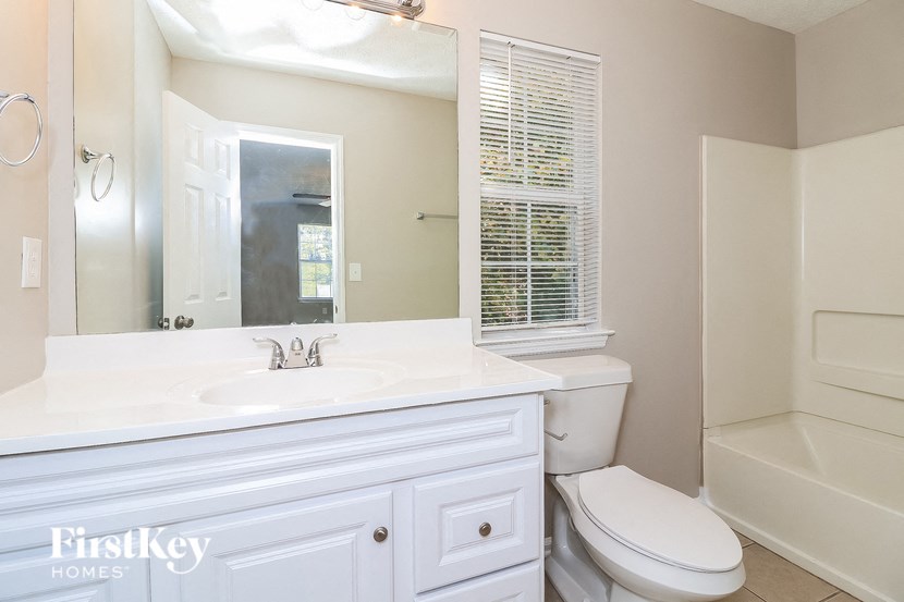 a bathroom with a sink toilet and a mirror