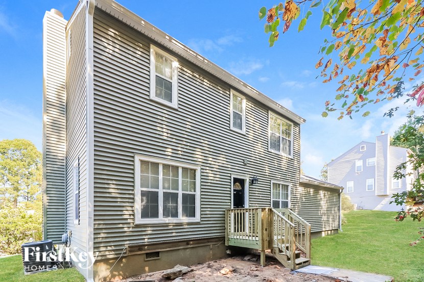 the back of a house with a yard and a deck