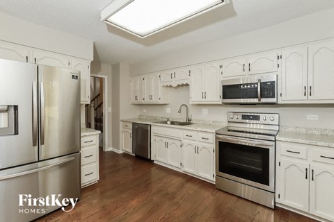 A kitchen with white cabinets and stainless steel appliances.