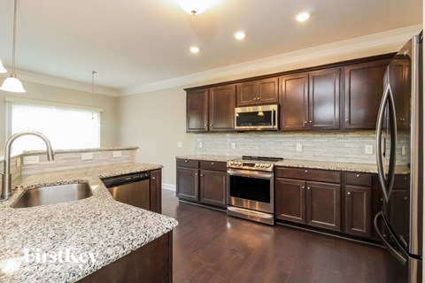 A kitchen with brown cabinets and granite countertops.