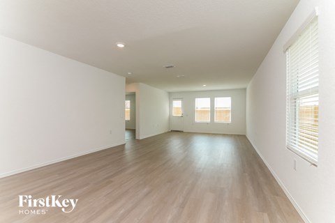 A spacious room with wooden floors and white walls.