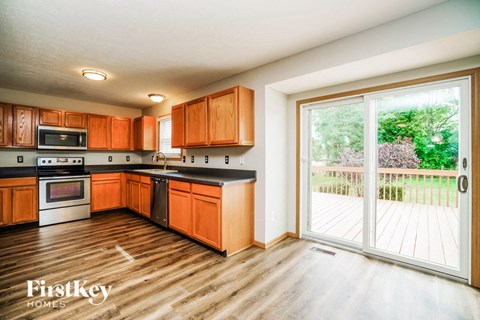 A kitchen with wooden cabinets and a wooden floor.