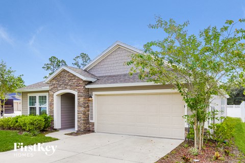 a small brick house with a white garage door