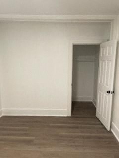 A room with a white door and a brown carpet.