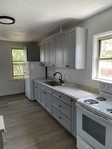 A kitchen with white cabinets and a white stove top oven.