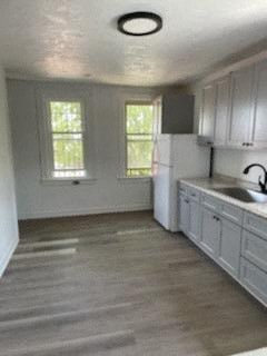 A kitchen with white cabinets and a window.