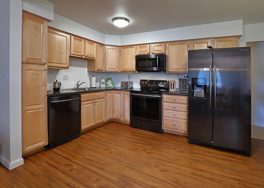 a kitchen with stainless steel appliances and wooden cabinets