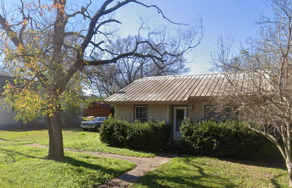 a house with a tin roof and a tree