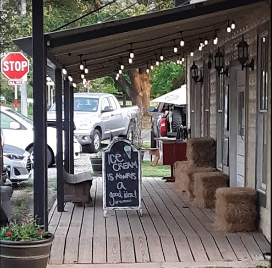 the front porch of a restaurant with a sign on it