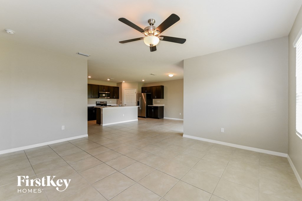 A spacious room with a ceiling fan and tiled flooring.