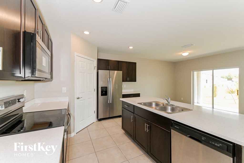 A kitchen with a stainless steel refrigerator and a white countertop.