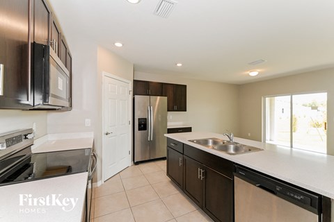 A kitchen with a stainless steel refrigerator and a white countertop.