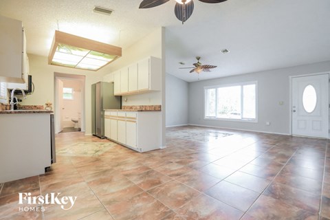 an empty kitchen and living room with a ceiling fan