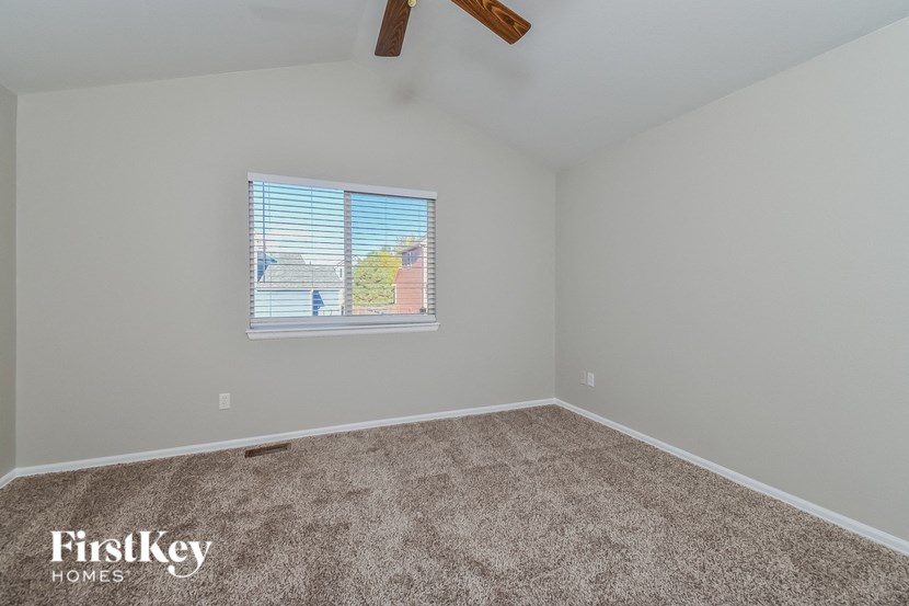 the living room of a home with carpet and a window