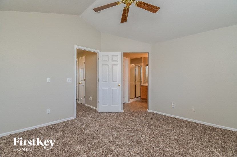 a bedroom with carpeting and a ceiling fan