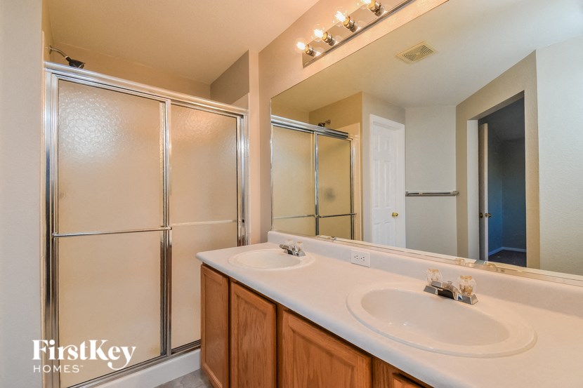 a bathroom with two sinks and a shower and a mirror