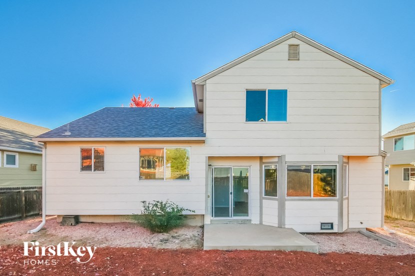 a small white house with a porch and a blue roof