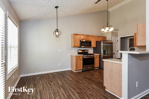 a kitchen with wood flooring and wooden cabinets
