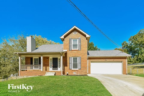 A brick house with a garage door and a chimney.