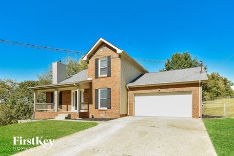 A brick house with a garage door is for sale.