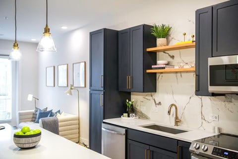 a kitchen with black cabinets and a white counter top and a sink