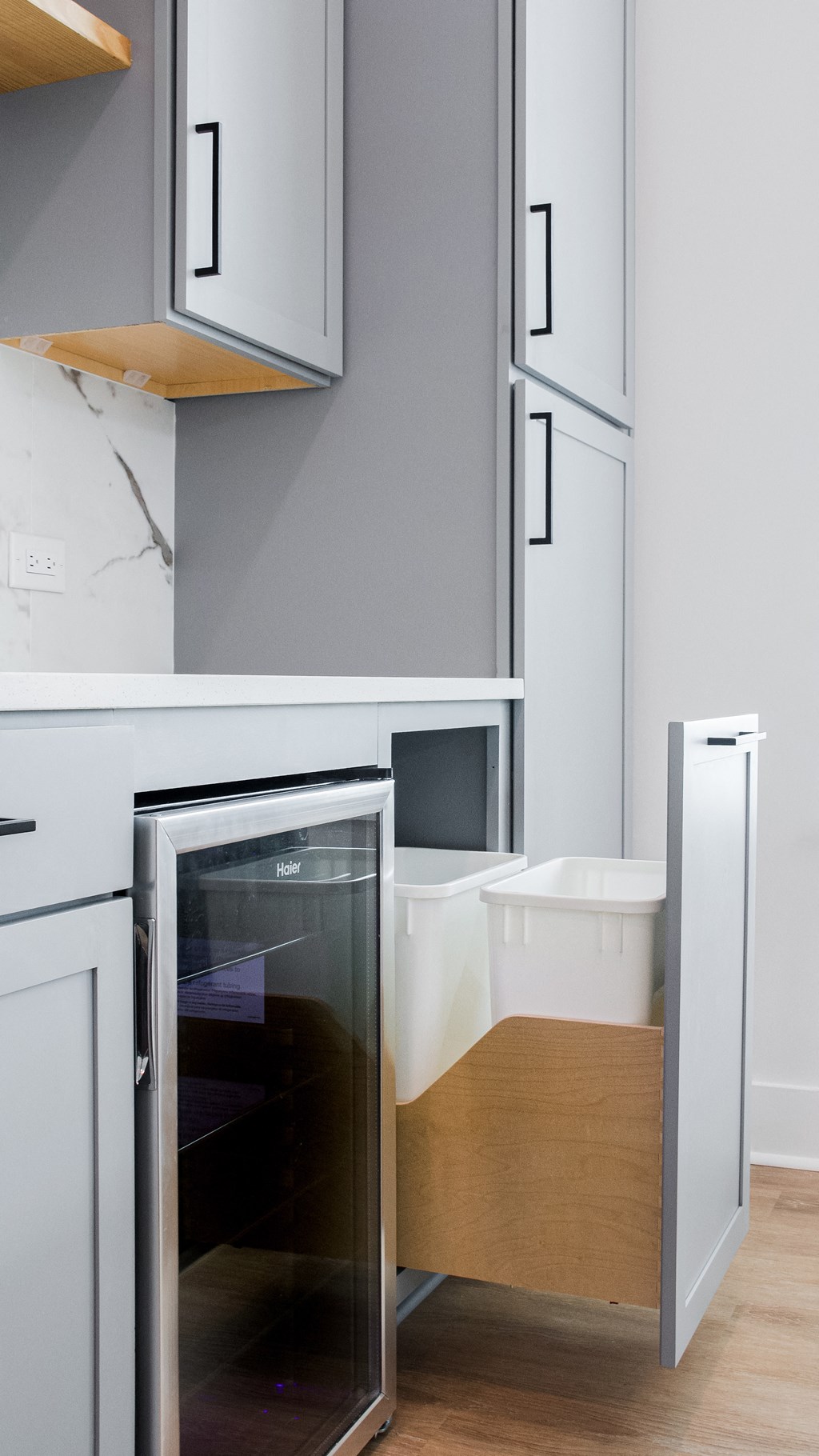 a small kitchen with white cabinets and a refrigerator and a microwave