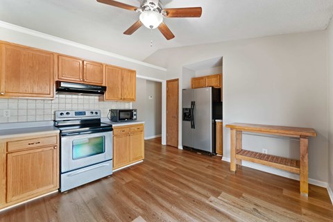 A kitchen with wooden cabinets and a stainless steel refrigerator.