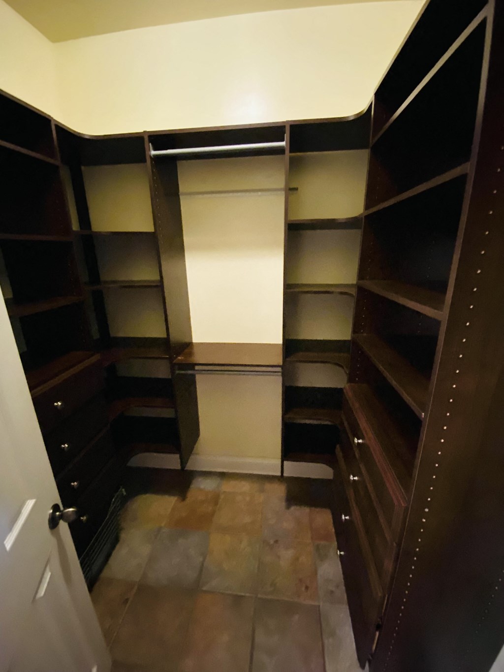 a walk in closet with shelves and a door