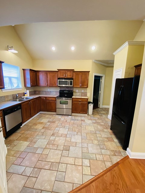 a kitchen with wooden cabinets and a tiled floor