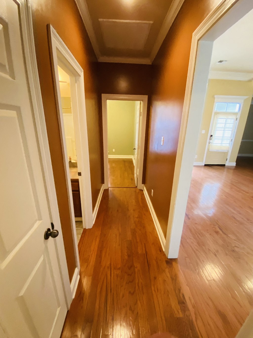 the hallway of a home with wooden floors and white doors