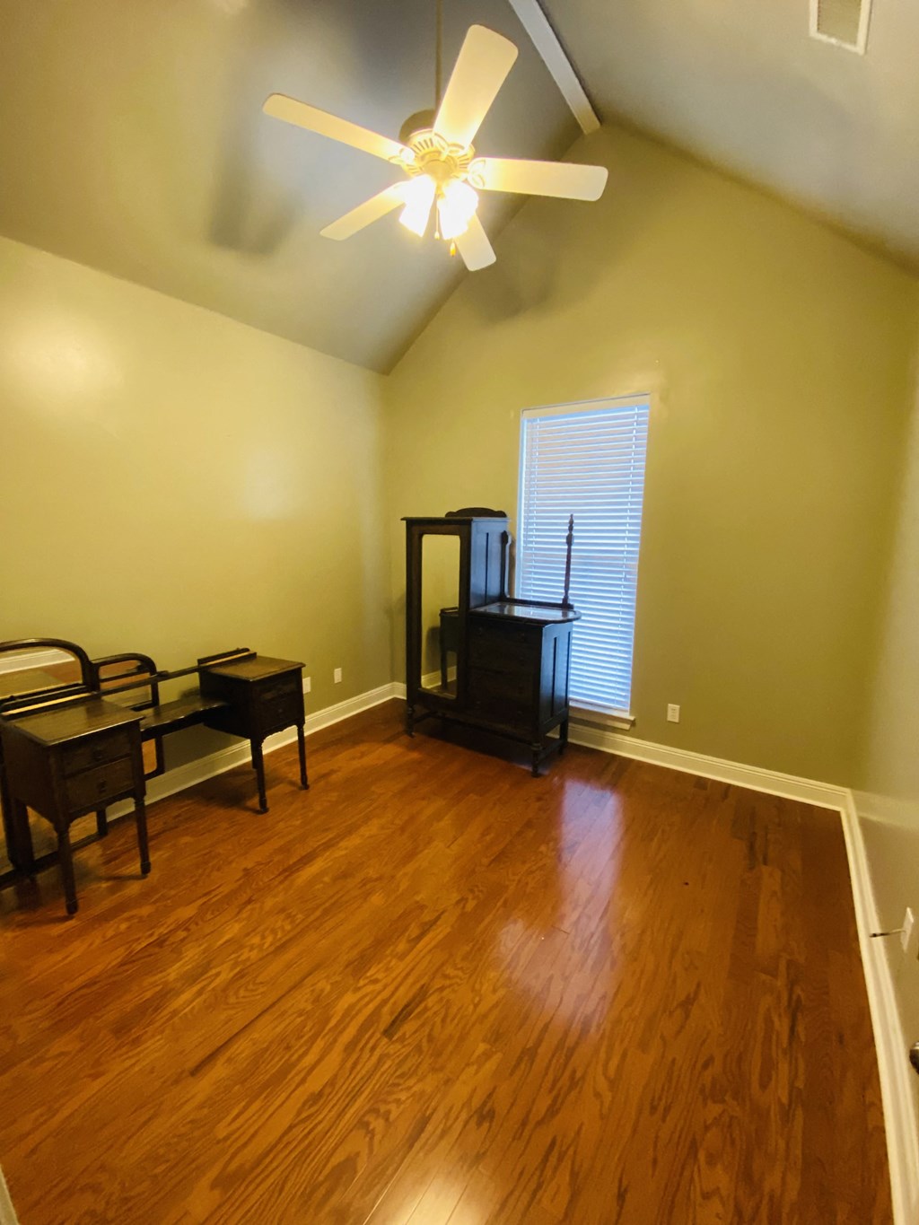 a living room with wood floors and a ceiling fan