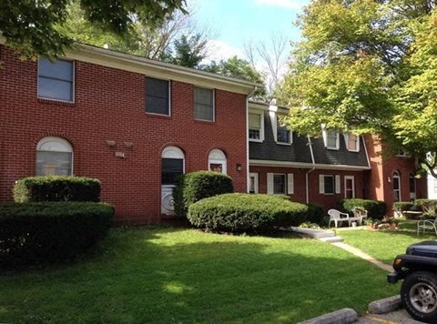 A red brick house with a green lawn in front.