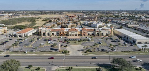 an aerial view of a parking lot with cars and buildings