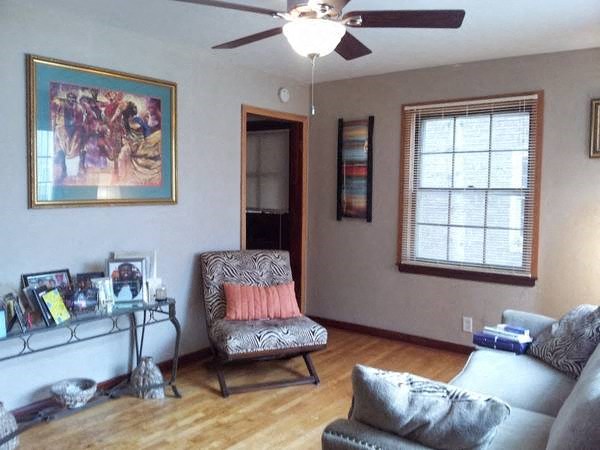 a living room with a couch and chair and a ceiling fan