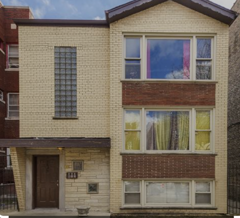 A two-story house with a brick facade and a brown door.