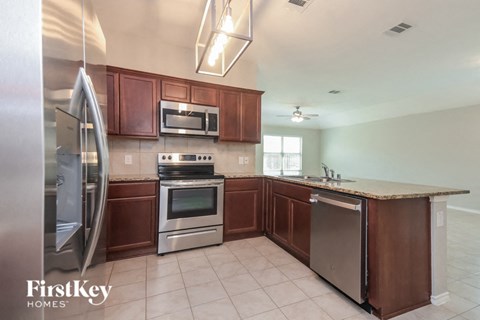 A kitchen with brown cabinets and a stainless steel refrigerator.